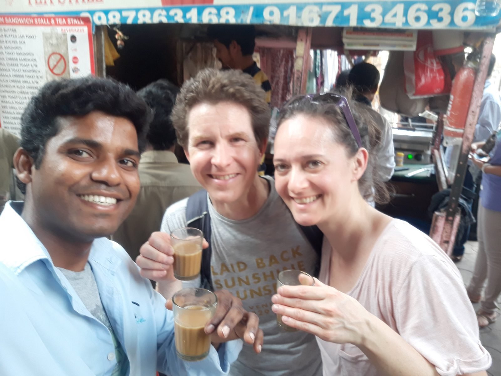 Balaji drinking chai with two guests at a tea stall on a Mumbai tour