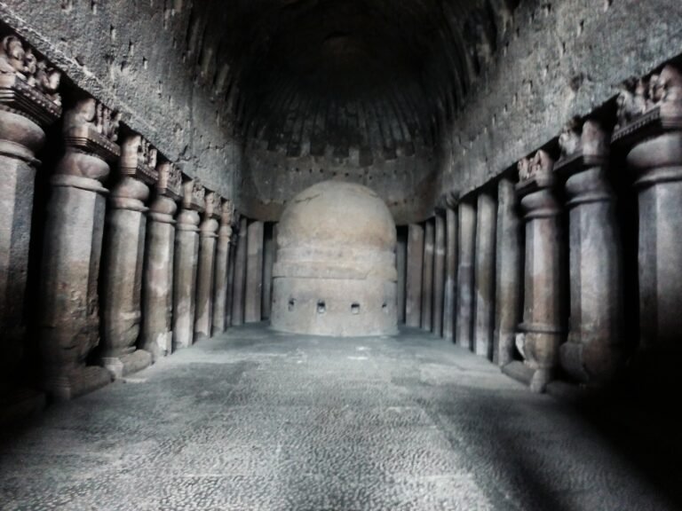 The great chaitya hall in Cave 3 at Kanheri Caves, Mumbai, with rows of carved pillars and the stupa at the far end